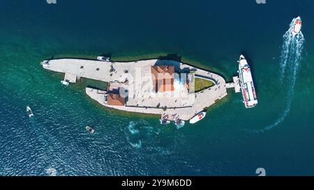 Aus der Vogelperspektive auf die künstliche Insel unserer Lieben Frau von den Felsen (Gospa od Škrpjela) in der Bucht von Kotor vor der Küste von Perast, Montenegro Stockfoto