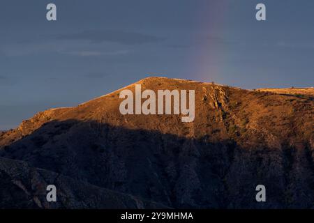 Mountain Hill mit verblasstem Regenbogen: Beeilen Sie sich und wünschen Sie sich etwas Stockfoto