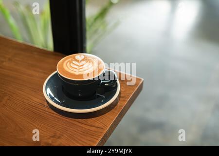 Eine Tasse Kaffee mit Latte Art auf einem Holztisch Stockfoto