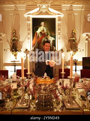 Evan Samson, der das Front-of-House-Team im Dumfries House leitet, zündet Kerzen an, während er dem Pink Dining Room, dem Lieblingszimmer des Königs im Dumfries House in Cumnock, Ayrshire, den letzten Schliff verleiht, wo Mitglieder der Öffentlichkeit die Möglichkeit erhalten, ein fest aus dem 18. Jahrhundert zu genießen, als Teil eines neuen maßgeschneiderten Dining Experience, das von der King's Foundation Charity geleitet wird. Bilddatum: Donnerstag, 10. Oktober 2024. Stockfoto