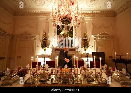 Evan Samson, der das Front-of-House-Team im Dumfries House leitet, zündet Kerzen an, während er dem Pink Dining Room, dem Lieblingszimmer des Königs im Dumfries House in Cumnock, Ayrshire, den letzten Schliff verleiht, wo Mitglieder der Öffentlichkeit die Möglichkeit erhalten, ein fest aus dem 18. Jahrhundert zu genießen, als Teil eines neuen maßgeschneiderten Dining Experience, das von der King's Foundation Charity geleitet wird. Bilddatum: Donnerstag, 10. Oktober 2024. Stockfoto