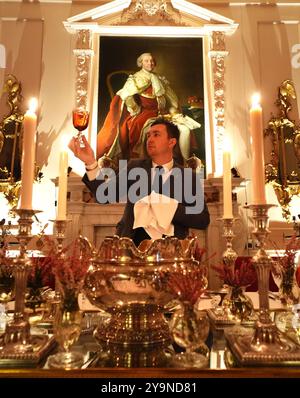 Evan Samson, der das Front-of-House-Team im Dumfries House leitet, überprüft die Gläser, während er dem Pink Dining Room, dem Lieblingszimmer des Königs im Dumfries House in Cumnock, Ayrshire, den letzten Schliff verleiht, wo Mitglieder der Öffentlichkeit die Möglichkeit erhalten, ein fest aus dem 18. Jahrhundert im Rahmen eines neuen maßgeschneiderten Dining Experience der King's Foundation Charity zu genießen. Bilddatum: Donnerstag, 10. Oktober 2024. Stockfoto