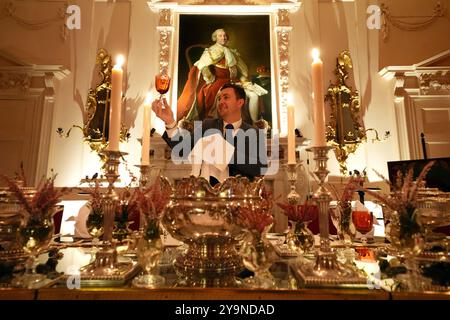 Evan Samson, der das Front-of-House-Team im Dumfries House leitet, überprüft die Gläser, während er dem Pink Dining Room, dem Lieblingszimmer des Königs im Dumfries House in Cumnock, Ayrshire, den letzten Schliff verleiht, wo Mitglieder der Öffentlichkeit die Möglichkeit erhalten, ein fest aus dem 18. Jahrhundert im Rahmen eines neuen maßgeschneiderten Dining Experience der King's Foundation Charity zu genießen. Bilddatum: Donnerstag, 10. Oktober 2024. Stockfoto