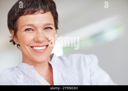 Reife Frau, glücklich und Porträt zu Hause oder zu Hause, um stolz in Lounge und Wohnzimmer zu entspannen. Immobilienmakler, Lächeln oder Gesicht eines selbstbewussten Maklers Stockfoto