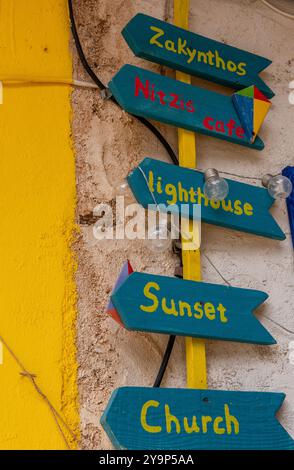 Handgemalte Schilder an der Seite eines Gebäudes in Keri auf der griechischen Insel Zante oder Zakynthos in Griechenland geben Wegbeschreibungen zu den Touristenattraktionen. Stockfoto