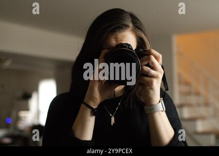 Junge Fotografin, die hinter der Fotokamera fotografiert Stockfoto