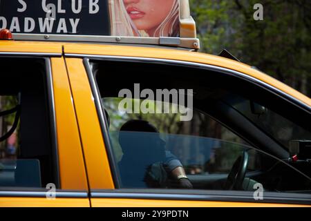 Gelber Fahrerhausfahrer mit Silhouettenwerbung mit Frau über New York City Stockfoto