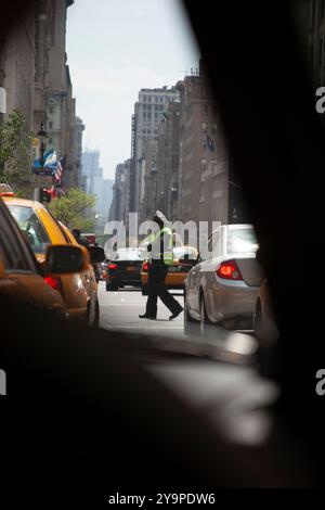 New York City Traffic Cop in einer belebten Straße mit viel Verkehr Stockfoto