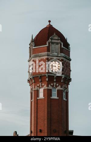 Nahaufnahme eines roten Backsteinturms mit einem Kuppeldach in der Abenddämmerung Stockfoto