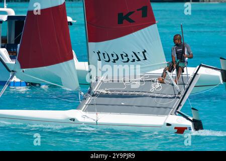 Randheli, Malediven - 24. Februar 2012: Ein maledivischer Segellehrer auf einem Katamaran von Hobie, während er den Kiel des Schiffes hochhält Stockfoto