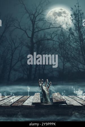 Gruselige Zombie-Hand, die aus einem Loch auf einem Holzsteg am See kommt, Horror und Halloween-Konzept Stockfoto