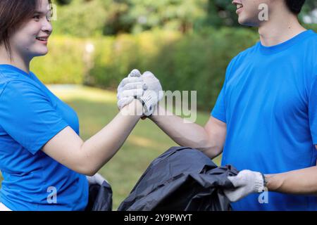 Junge Freiwillige arbeiten mit Enthusiasmus und Teamgeist bei der Reinigung von Außenbereichen zusammen Stockfoto