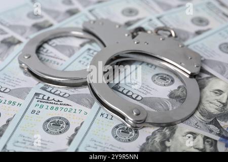 Corruption concept. Handcuffs on dollar banknotes, closeup Stock Photo