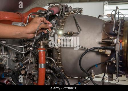 Nahaufnahme der manuellen Prüfung von Komponenten des Hubschrauberdüsenmotors mit Drähten und Rohren – Stockfoto Stockfoto