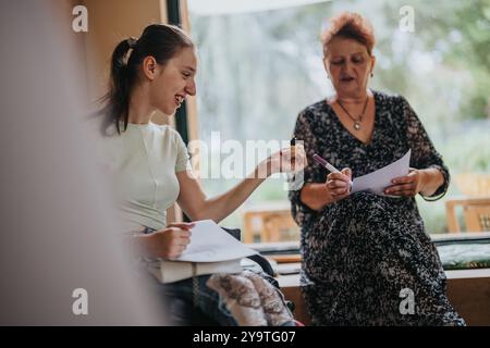 Junge Frau im Rollstuhl, die kreativen Kunstunterricht genießt Stockfoto