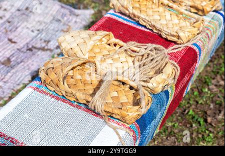 Birchen gewebte Bastschuhe traditionelle russische Schuhe. Bast-Schuhe aus Weidenholz auf der alten Haustier-Fußmatte Stockfoto