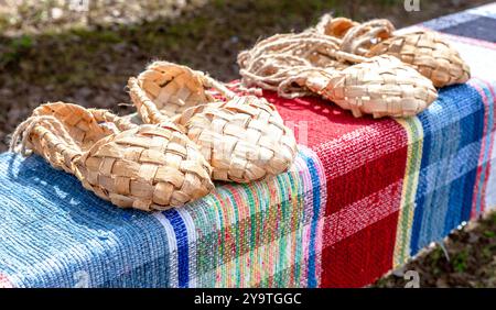 Birchen gewebte Bastschuhe traditionelle russische Schuhe. Bast-Schuhe aus Weidenholz auf der alten Haustier-Fußmatte Stockfoto