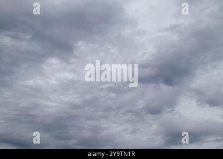 Graue Regenwolken voller Regen am Himmel. Bedeckter Himmel mit dunklen Wolken. Dunkler Himmel vor einem Gewitter Stockfoto