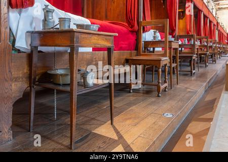 Beaune, Frankreich - 29. April 2024: Innenraum des Hauptzimmers mit roten Betten im Hospices de Beaune oder Hotel-Dieu de Beaune, einer ehemaligen karitativen Almshouse in der antiken Stadt Beaune in der Region Burgund in Frankreich Stockfoto