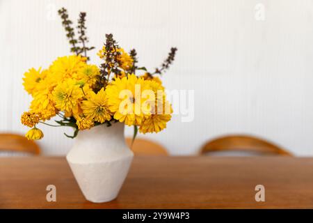 Strauß aus gelben Rudbeckia-Blumen ist in weißer Vase auf Holztisch, Nahaufnahme Foto mit selektivem Weichfokus Stockfoto