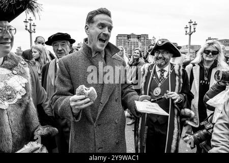 Hollywood-Schauspieler Damian Lewis isst Einen Donut zum Frühstück, bevor er den Annual Sheep Drive über die Southwark Bridge in London führt. Stockfoto