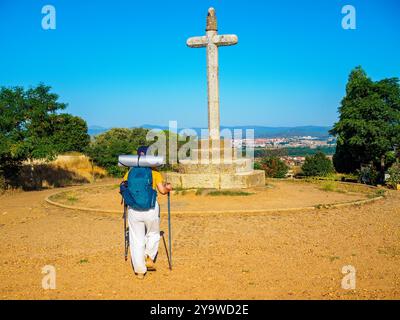 Ein Pilger, der auf dem Jakobsweg in San Justo de la Vega, Spanien, zum Kreuz von Santo Toribio geht. Stockfoto