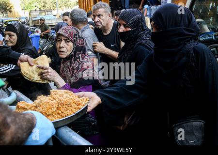 Beirut, Libanon. Oktober 2024. Vertriebene Libanesen, die aus ihren südlichen Dörfern und Häusern geflohen sind, erhalten warme Mahlzeiten in einer Wohltätigkeitsküche in Beirut. Hunderttausende Menschen sind aufgrund des eskalierenden Konflikts zwischen Israel und der pro-iranischen Hisbollah aus dem Südlibanon geflohen. Marwan Naamani/dpa/Alamy Live News Stockfoto