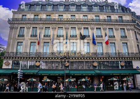 Hektik und Charme: Straßenleben in zwei Pariser Sehenswürdigkeiten, dem Grand Hotel und dem Café de la Paix in Paris Stockfoto