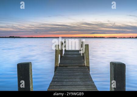 Foto von einem Holzsteg am See. Der Himmel ist wunderschön gefärbt. Bei Giethoorn, Weerribben in den Niederlanden. Stockfoto