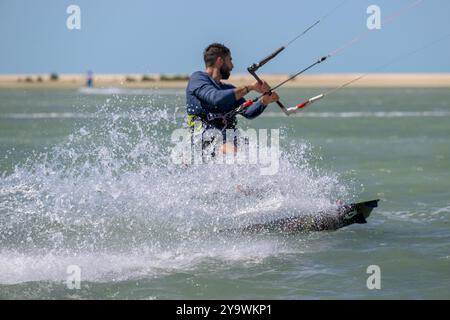 Doha Katar - 9. Mai 2024: Professioneller Kiter macht den schwierigen Trick vor einem wunderschönen Hintergrund. Kitesurfen Kiteboarding Action Fotos Mann unter Wabe Stockfoto