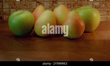 Ganze Birnen und Äpfel auf hölzernem Hintergrund. Stockfoto