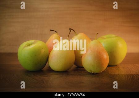 Ganze Birnen und Äpfel auf hölzernem Hintergrund. Stockfoto