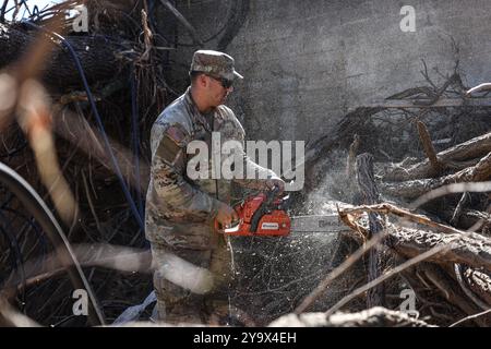 Marshall, Usa. Oktober 2024. Der US-Army-Spezialist Luke Shirk, der der 887th Engineer Support Company zugeteilt wurde, entfernt nach dem Hurrikan Helene am 10. Oktober 2024 in Marshall, North Carolina, mit einer Kettensäge heruntergekommene Bäume. Quelle: Sgt. Nicholas Session/US Army Photo/Alamy Live News Stockfoto