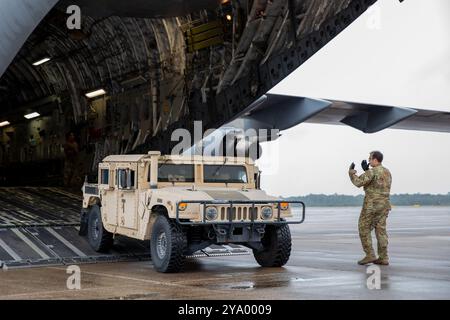 Albert rein, Stab der New York Air National Guard, der der 137th Airlift Squadron, 105th Airlift Wing, zugewiesen ist, führt ein High Mobility Multipurpose Radfahrzeug aus einem C-17 Globemaster III am Cecil Airport in Jacksonville, Florida, 9. Oktober 2024. New York Air und Army National Guardsmen wurden kürzlich mobilisiert, um Gemeinden in Florida zu unterstützen, die vom Hurrikan Milton betroffen waren. (Foto der Nationalgarde der US-Armee von SPC. Joseph Liggio) Stockfoto