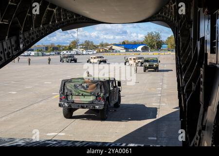 Soldaten der New York Army National Guard, die dem 27th Infantry Brigade Combat Team zugeteilt sind, bereiten sich vor, High Mobility Multipurpose Radfahrzeuge in einen C-17 Globemaster III auf der Hancock Field Air National Guard Base in Syracuse, NY, 9. Oktober 2024 zu laden. New York ist einer von vielen staaten, die Personal und Ausrüstung der Nationalgarde nach Florida schicken, um Hilfe bei Hurrikan Milton zu leisten. (Foto der Nationalgarde der US-Armee von SPC. Joseph Liggio) Stockfoto