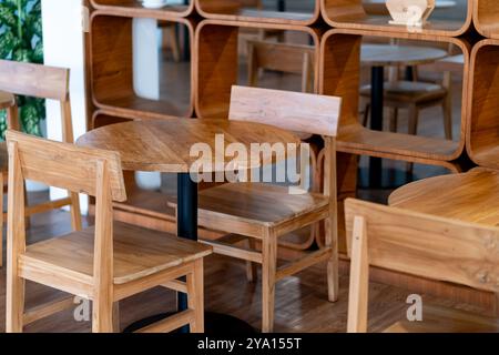 Eine gemütliche Einrichtung mit Holzmöbeln, einschließlich runder Tische und Stühle. Das Design ist modern mit einer warmen Farbpalette, die eine hölzerne Frau zeigt Stockfoto