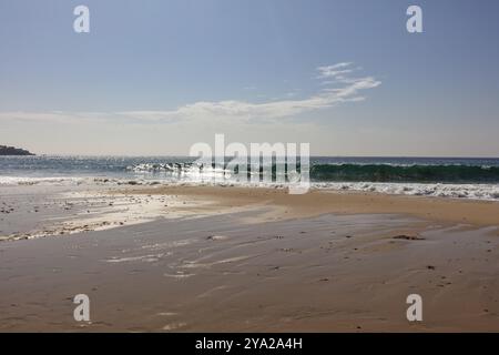 Brechende Wellen an einem ruhigen Strandabschnitt unter klarem Himmel, Tarifa Stockfoto