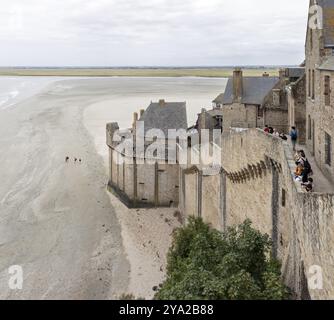 Historische Gebäude Grenzen an einen ausgedehnten Sandstrand mit Blick auf das Meer und die Landschaft, Le Mont-Saint-Michel Stockfoto