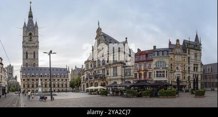 Historische Gebäude und Glockenturm in der Abenddämmerung auf einem belebten Stadtplatz, Gent Stockfoto