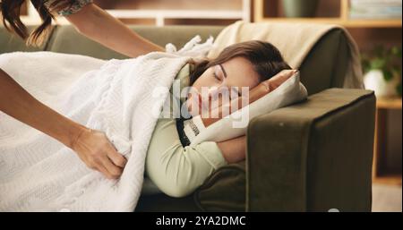 Schlafen, müde und Frau auf Sofa mit Decke zum Ausruhen, Träumen und Nickerchen zu Hause. Haus, Wohnzimmer und Mutter mit Person mit Federdecke, Kissen und Stockfoto