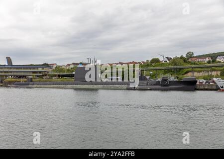 U-Boot am Hafen mit Stadt im Hintergrund unter bewölktem Himmel, Rügen Stockfoto