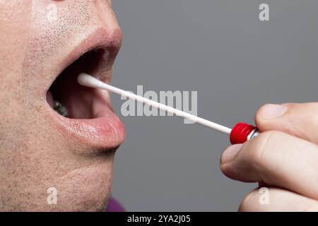 Der Mann benutzt ein DNA-Reagenzglas und einen Wattestäbchen, Wischtest Stockfoto