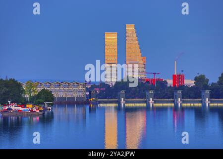 Zwei moderne Wolkenkratzer spiegeln sich in der Dämmerung im ruhigen Wasser wider: Roche Towers, Hoffmann-la Roche, höchstes Gebäude der Schweiz, Basel, Kanton Baselstad Stockfoto