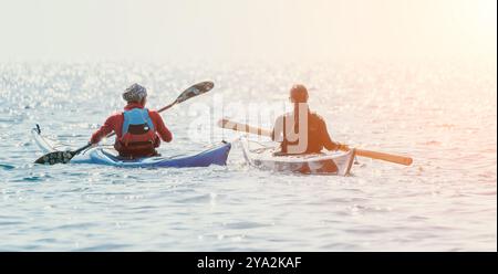 Kajak Paddle Water zwei Kajakfahrer paddeln auf ruhigen Gewässern bei Sonnenuntergang Stockfoto