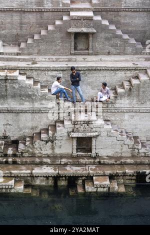 Jodhpur, Indien, 23. März 2024: Eine Gruppe von Menschen sitzt auf den Stufen des Treppenhauses Toorji Ka Jhalra im historischen Stadtzentrum Asiens Stockfoto