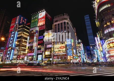 Shinjuku, Japan, 18. Mai 2019: Neonschilder beleuchten Tokios geschäftiges Stadtviertel Shinjuku bei Nacht entlang der Yasukuni-dori Ave mit Menschenmassen in Asien Stockfoto