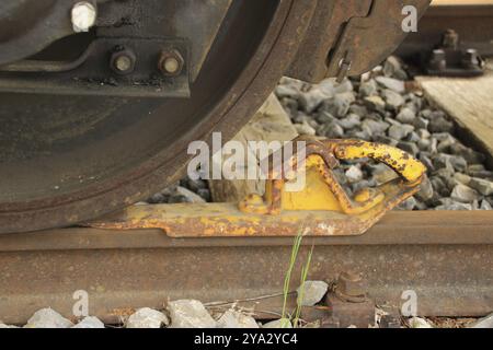 Der Eisenbahnwagen ist mit einer Bremsbacke gegen Wegrollen gesichert Stockfoto