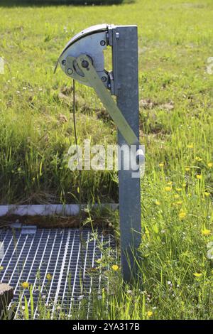 Die Seilwinde aus Edelstahl steht auf einem Gitter auf einem Regenwasserbecken Stockfoto