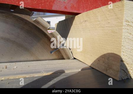 Ein Stück Holz liegt am Sägeblatt einer Kreissäge Stockfoto
