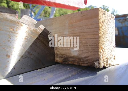 Ein Stück Holz liegt am Sägeblatt einer Kreissäge Stockfoto